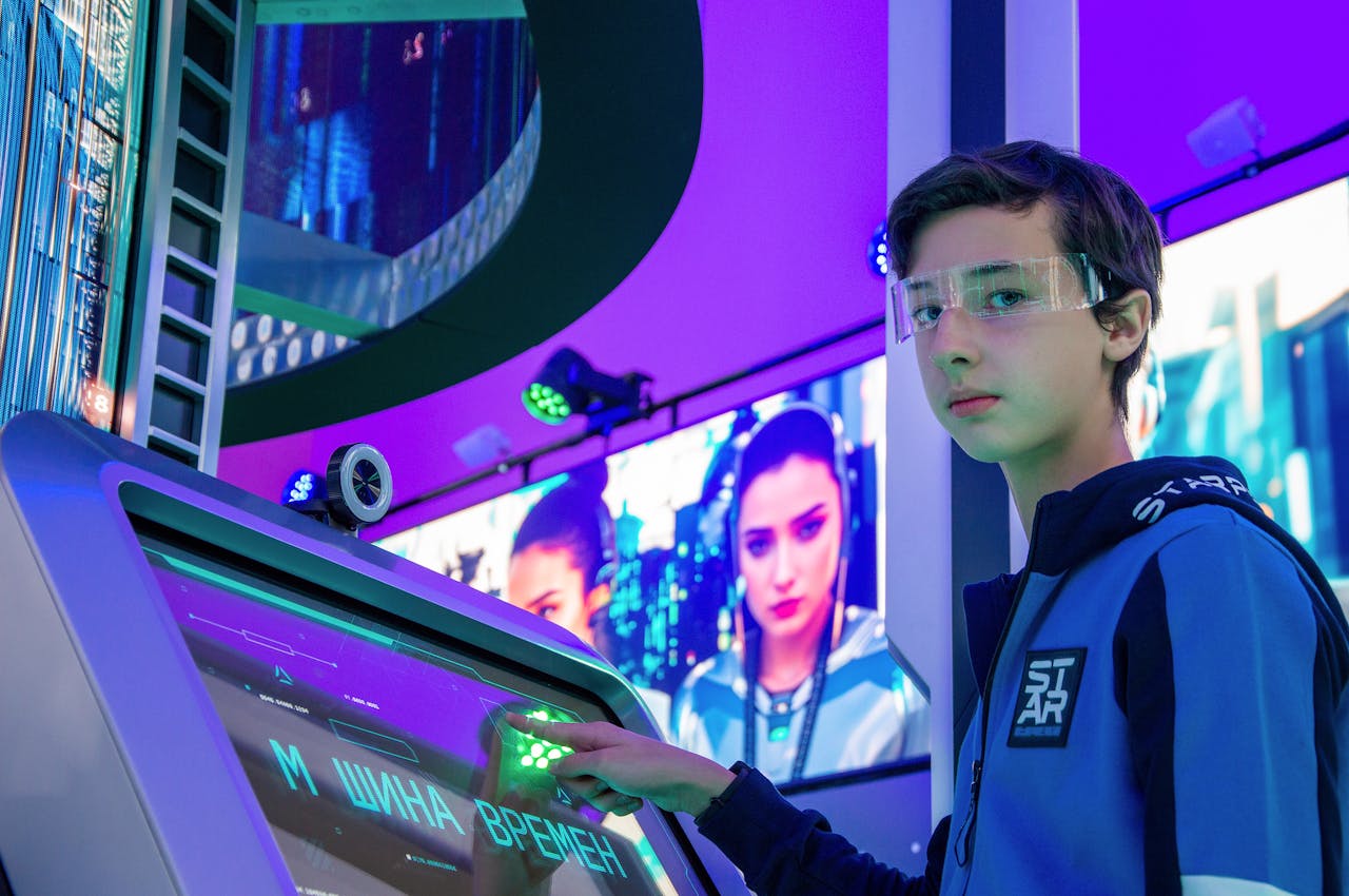 Teen boy in a digital room interacting with a futuristic touchscreen device wearing protective goggles.
